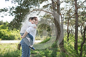 Happy family! Mother with son child playing having fun together on the grass in sunny summer day, life moment