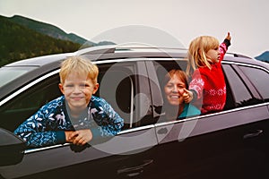 Happy family- mother with son and daughter- travel by car