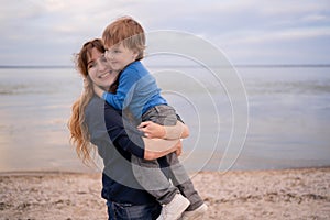Happy family. Mother and son in a deep moment of love during sunset at beach. Concept of union and tender connection