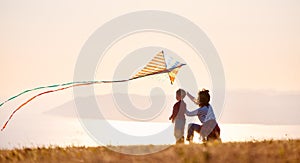 Happy family  mother and son  launch  kite on nature at sunset