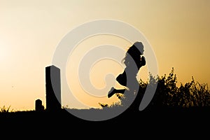 Happy family. A mother and son playing in grass fields outdoors at evening silhouette.Vintage Tone and copy space