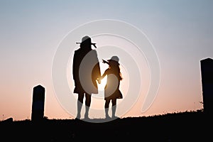 Happy family. A mother and son playing in grass fields outdoors at evening silhouette.Vintage Tone and copy space