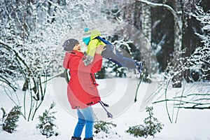 a happy family. mother and three children playing in the winter forest