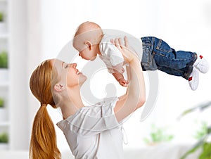 Happy family mother throws up child baby at home