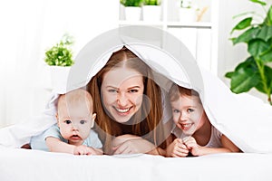 Happy family mother and two children, son and daughter in bed un