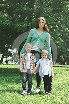 Happy family! Mother with two children sons walks on nature