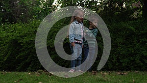 Happy family mother, two Three little siblings kids are blowing soap bubbles and enjoying summer holidays in garden or