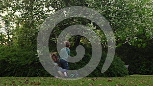 Happy family mother, two Three little siblings kids playing running hug kiss mom enjoying summer holidays in garden or