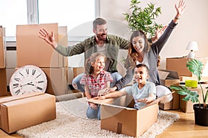 Happy family moving in their new home and having a playtime with their children