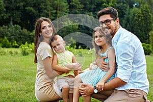 Happy Family In Nature. Beautiful Parents And Children Outdoors