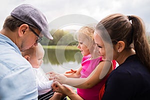 Happy family in nature by the lake in summer.