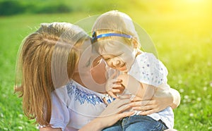 Happy family on nature mother tickle baby daughter and laugh