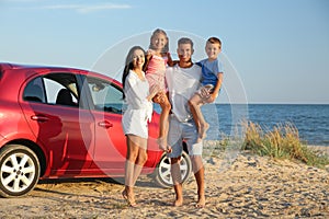 Happy family near car on sandy beach. Summer trip