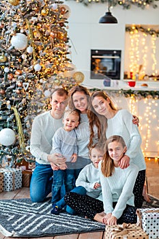 Happy family near the Christmas tree with the present boxes