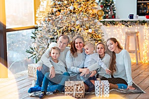 Happy family near the Christmas tree with the present boxes