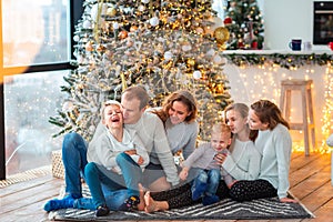 Happy family near the Christmas tree with the present boxes