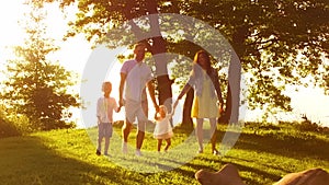 Happy family near the sea. Field and trees in countryside. Warm colors of sunset or sunrise. Loving parents and