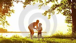 Happy family near the sea. Field and trees in countryside. Warm colors of sunset or sunrise. Loving parents and