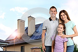 Family near their house with solar panels. Alternative energy source photo