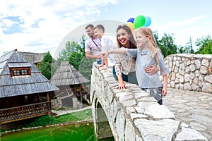 Happy family observing the surroundings from the side of the bridge