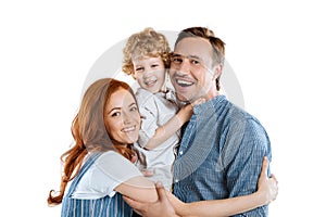 Happy family with one child hugging and smiling at camera