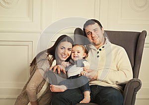 Happy family with one year old baby girl indoor