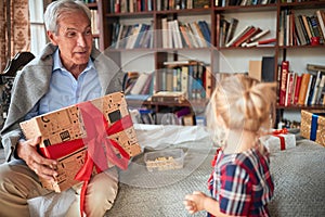 Happy family open presents on Christmas morning.grandfather giving present his little granddaughter