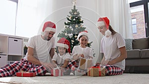 Happy family opening Christmas gifts at home