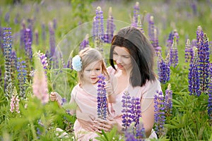 Happy family outdoor. Middle-aged mother hugs her daughter in field. Mother's Day