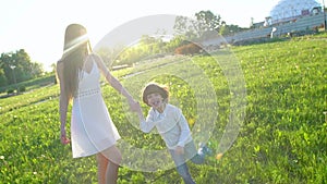 Happy family outdoors. mother and son little boy running enjoying nature summer at sun day. mother and child, cute boy