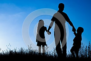 Happy family outdoors in the park silhouette