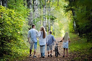 Happy family outdoors spending time together. Father, mother, daughter and son are having fun in a summer park at summer