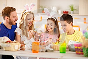 Happy family painting eggs