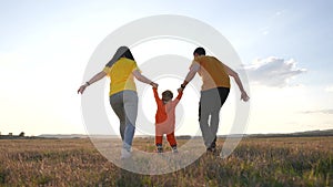 happy family. parent a baby together run in the park at sunset. people in park concept. mom dad daughter and son swing