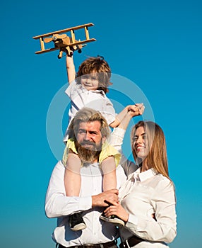 Happy family, Parent giving piggyback ride to children. Mother father and child son on nature on sky. Kid boy with toy