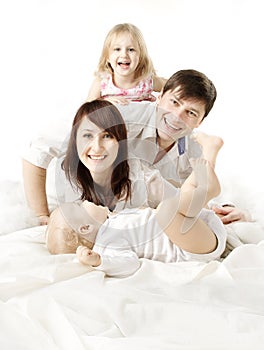 Happy family: parents playing with kids in bed