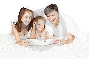Happy family parents reading book with child