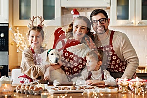 Happy family parents with two kids and golden retriever puppy while making xmas cookies at home