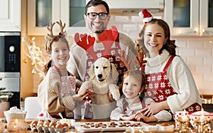 Happy family parents with two kids and golden retriever puppy while making xmas cookies at home