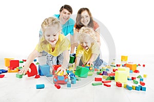 Happy family. Parents with two kids playing toys blocks
