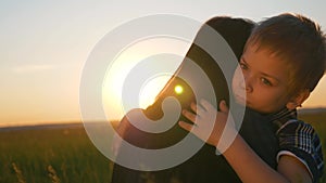Happy family in the park. Mom and son love in the park. Silhouette of a happy family at sunset. Mom hugs her son in the