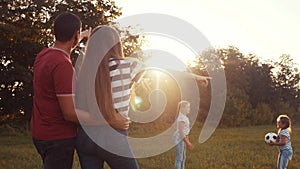 Happy family in the park playing ball having fun. kid dream together concept. children throw a ball in the park on the