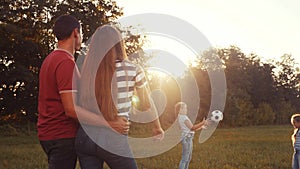 Happy family in the park playing ball having fun. kid dream together concept. children throw a ball in the park on the