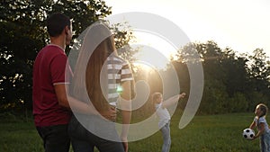 Happy family in the park playing ball having fun. kid dream together concept. fun children throw a ball in the park on