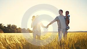 Happy family in park wheat field. Friendly family walks in a wheat field with two children baby toddlers in summer