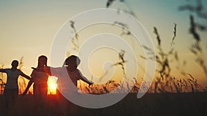 happy family. people in park children a kid together run in park at sunset silhouette. mom dad daughter and son run