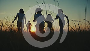 happy family. people in park children a kid together run in park at sunset silhouette. mom dad daughter and son run