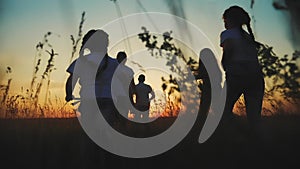 happy family. people in park children a kid together run in park at sunset silhouette. mom dad daughter and son run