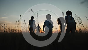 Happy family. People in park fun children a kid together run in park at sunset silhouette. Mom dad daughter and son run