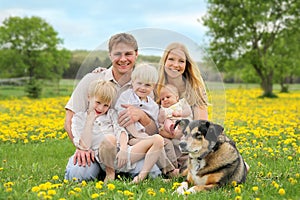 Happy Family and Pet Dog in Flower Meadow